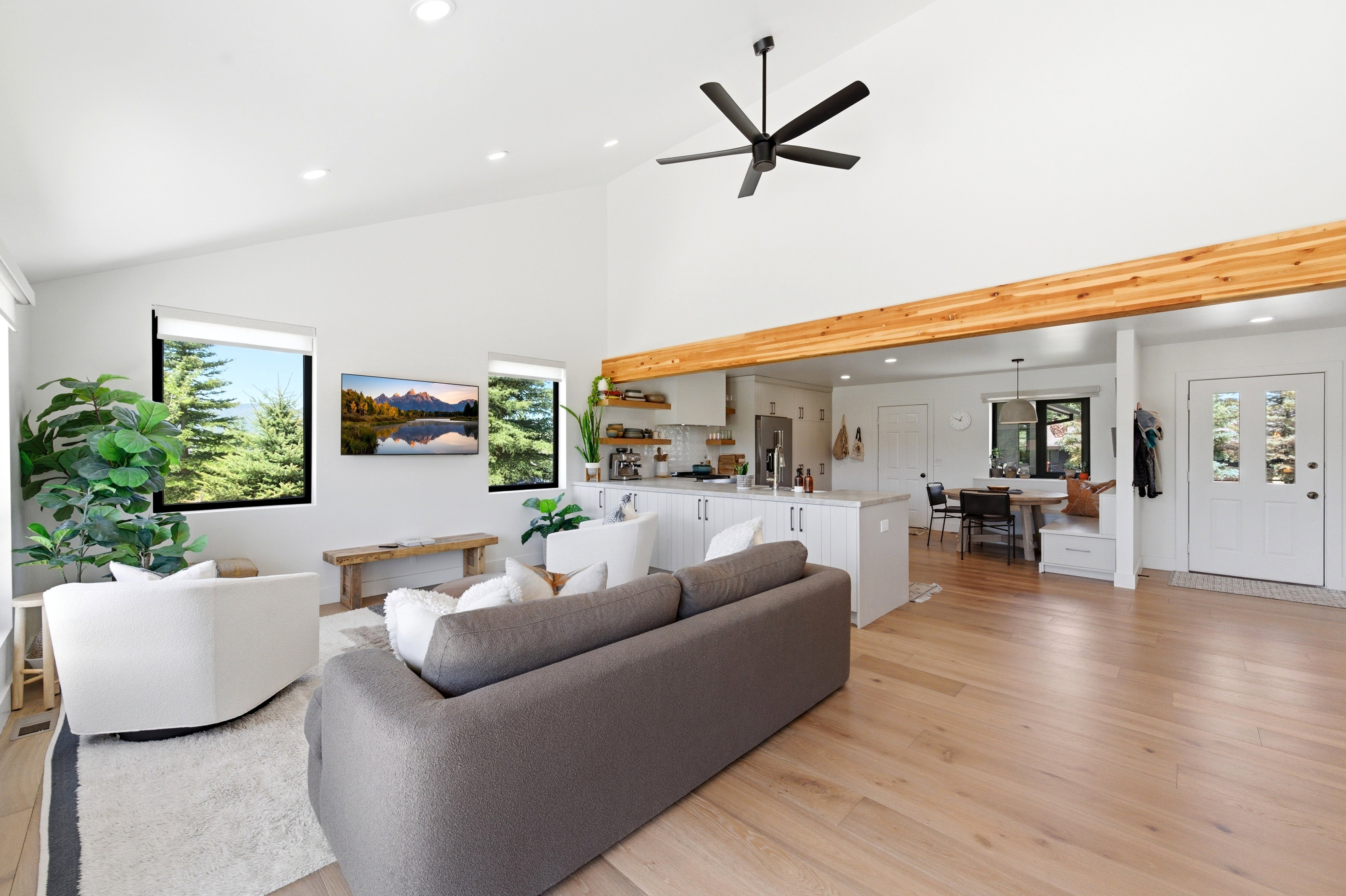 Vaulted living area featuring light wood-finish flooring, recessed lighting, and a large ceiling fan