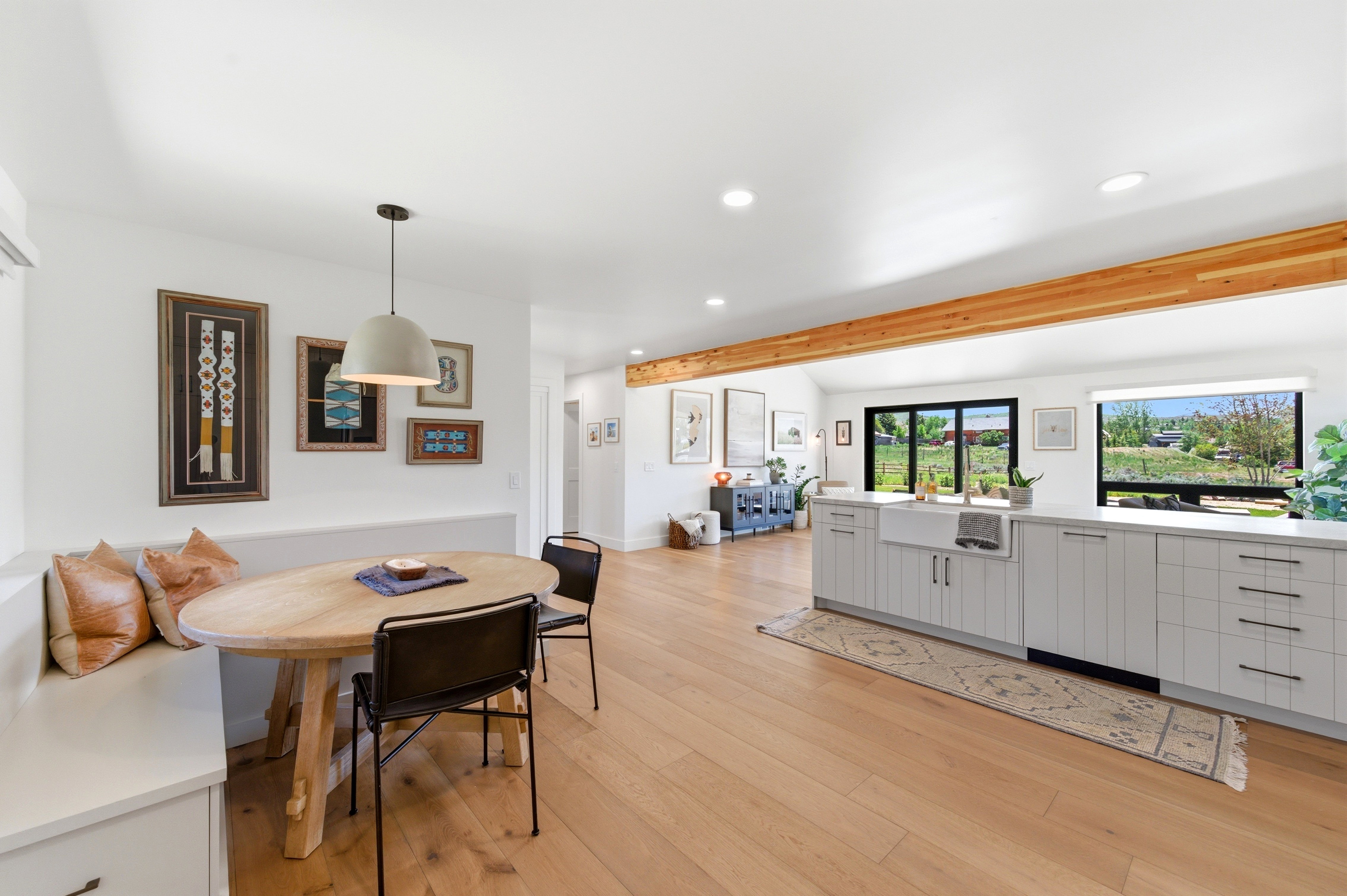 Open-concept living space with light wood-finish flooring, white walls, and recessed lighting