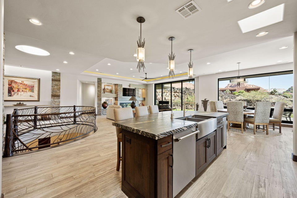 Open-concept kitchen with a large island featuring a farmhouse sink and stone countertop