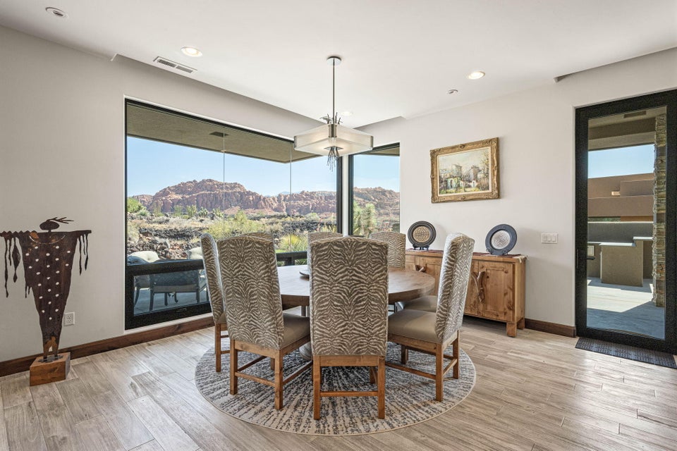 Dining area featuring large windows, light-toned tile flooring, recessed lighting, and a modern chandelier