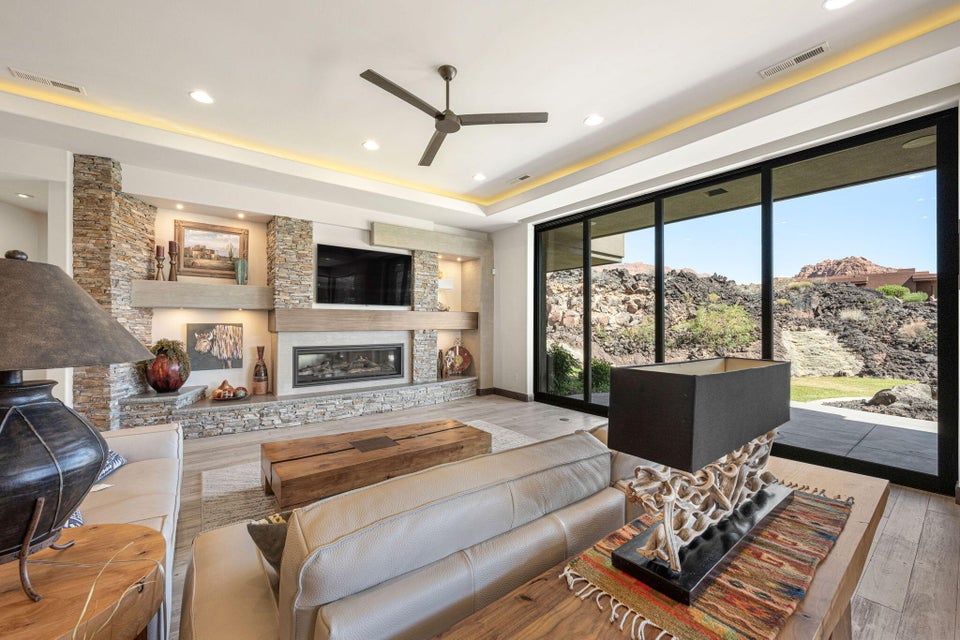 Living area featuring a floor-to-ceiling stone-faced fireplace wall with integrated media storage and a linear gas fireplace