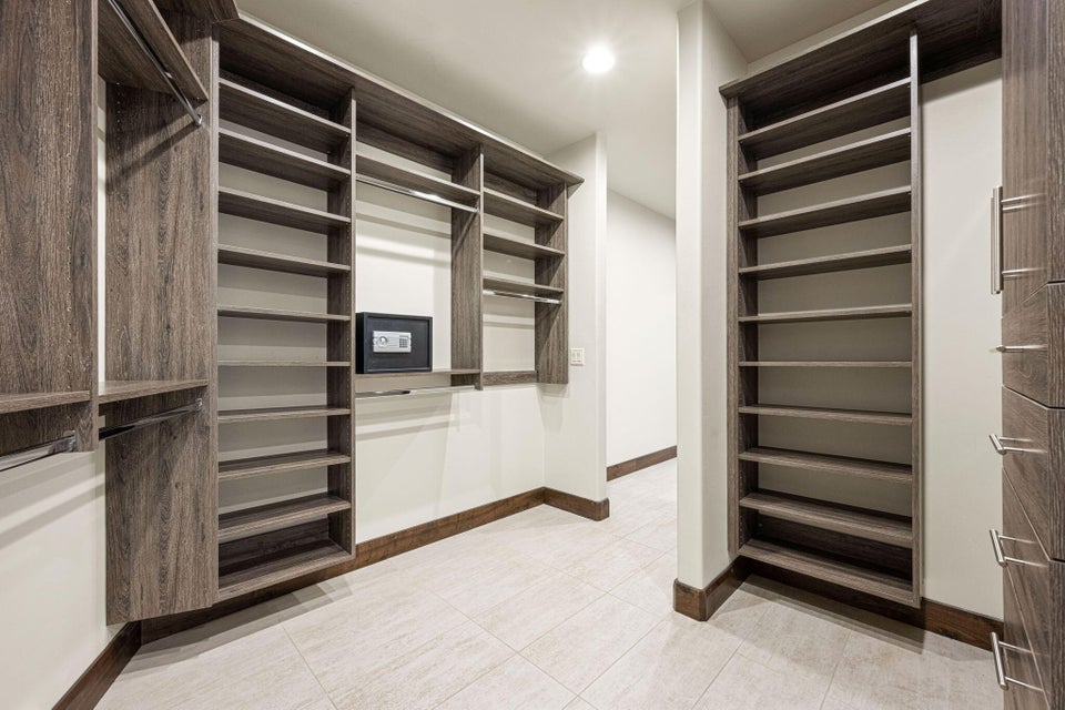Custom wood-finish cabinetry featuring extensive shelving and hanging rods