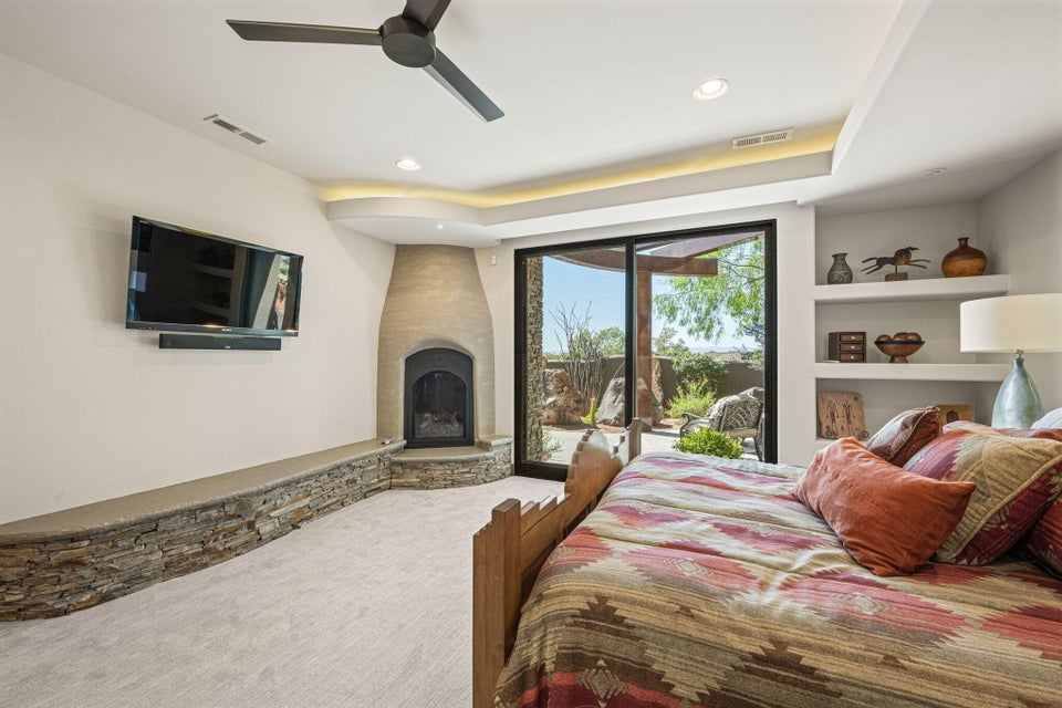 Spacious room featuring a corner fireplace with a stucco surround and stone base, complemented by a built-in stone bench