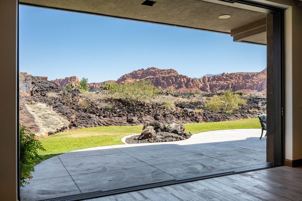 Expansive patio with stamped concrete flooring, offering direct access to a landscaped lawn