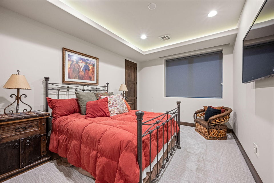 Room featuring recessed lighting, tray ceiling, dark wood door, window with roller shade, and light-toned flooring