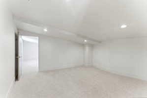 Bright, neutral-toned room featuring light-colored carpeting and recessed lighting