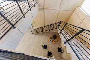 Multi-level interior featuring light wood-finish flooring and paneling, complemented by contemporary black metal railings