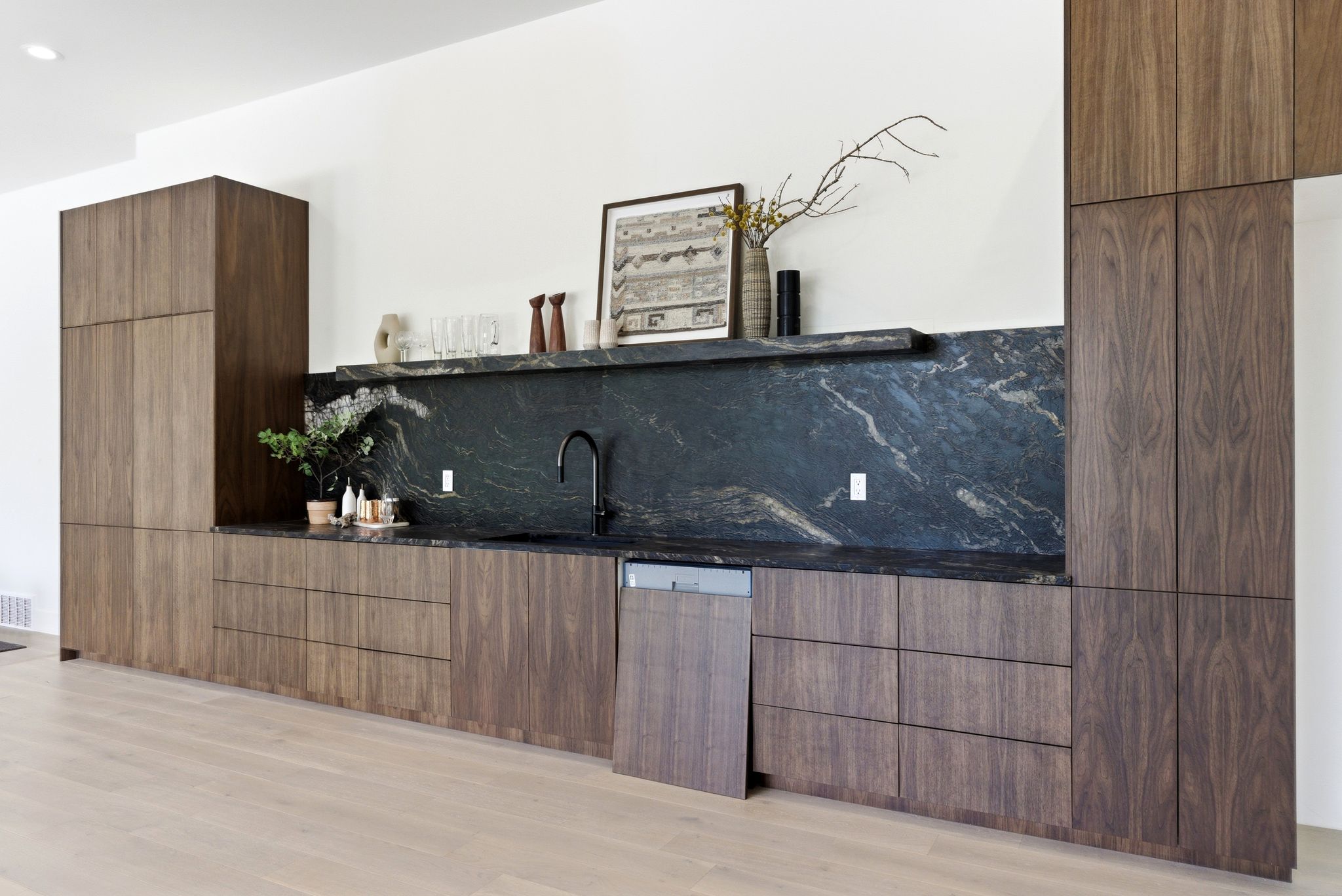 Integrated walnut-finish cabinetry with a built-in dishwasher
