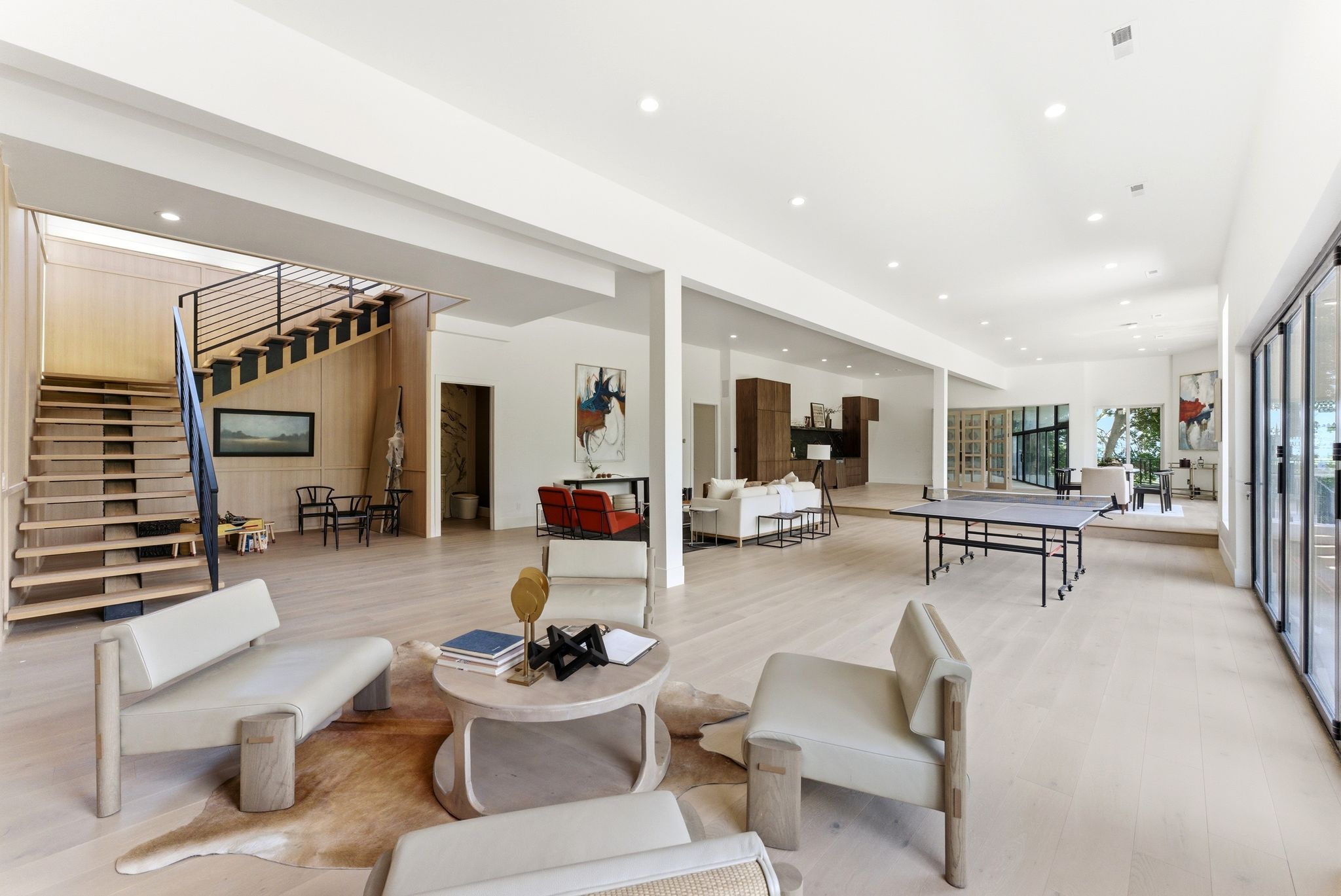 Expansive open-concept living space with light wood-finish flooring