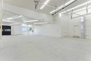 Spacious interior featuring a concrete floor, bright overhead lighting, and white painted walls