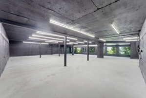 Expansive open space featuring exposed concrete walls and ceiling