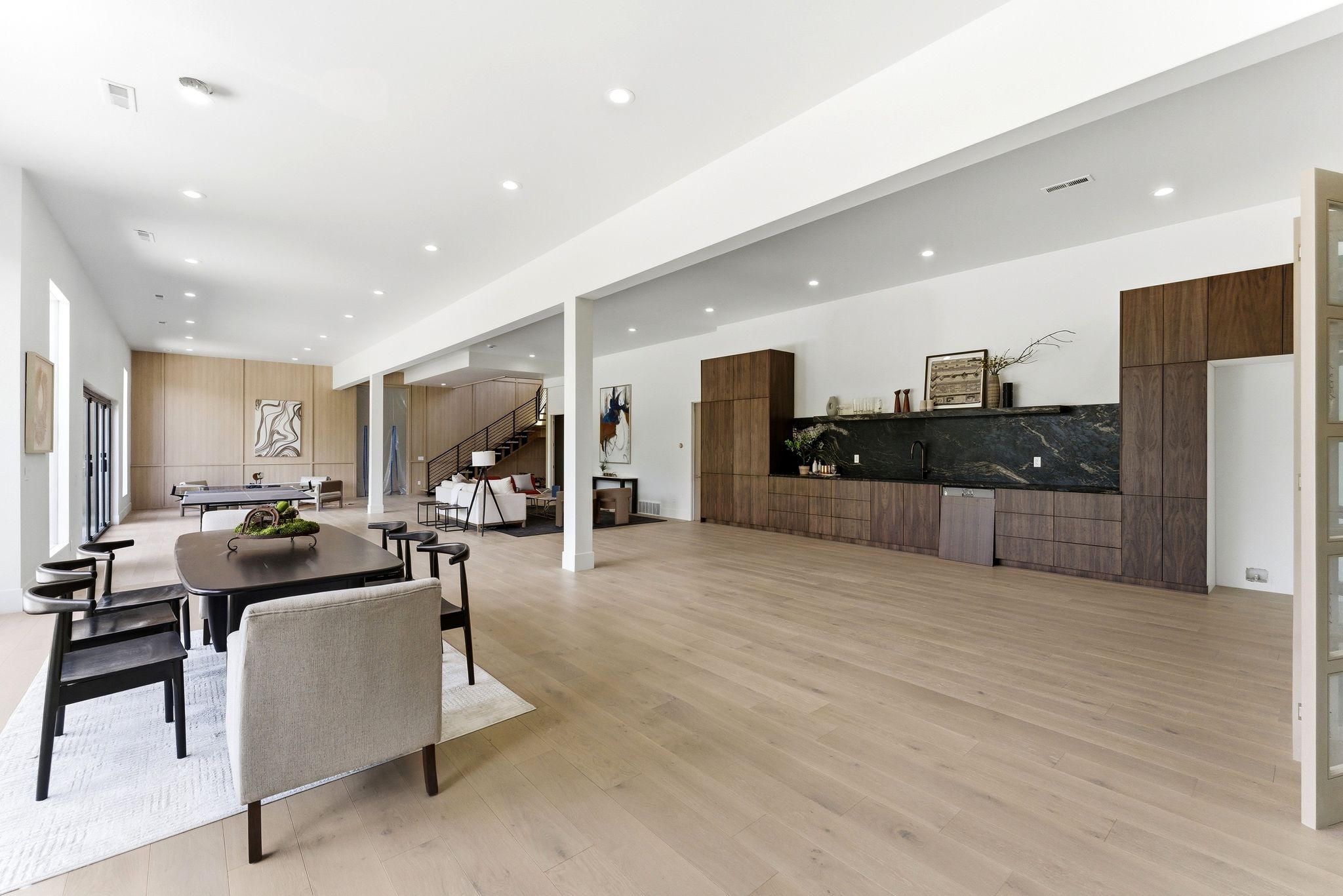 Expansive open-concept living space with light wood-finish flooring