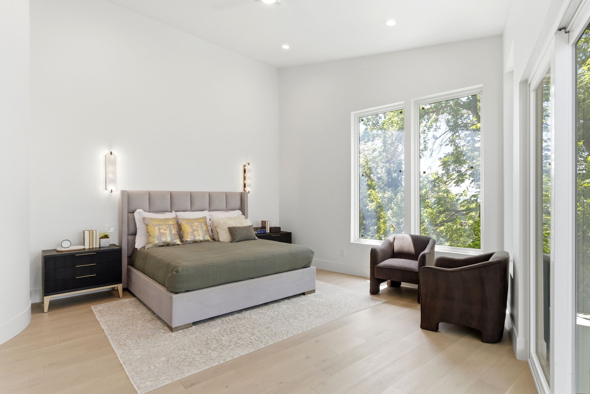 Spacious bedroom featuring light wood-finish flooring, vaulted ceilings, and recessed lighting