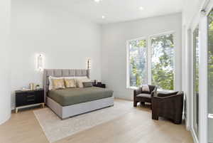 Spacious bedroom featuring light wood-finish flooring, vaulted ceilings, and recessed lighting
