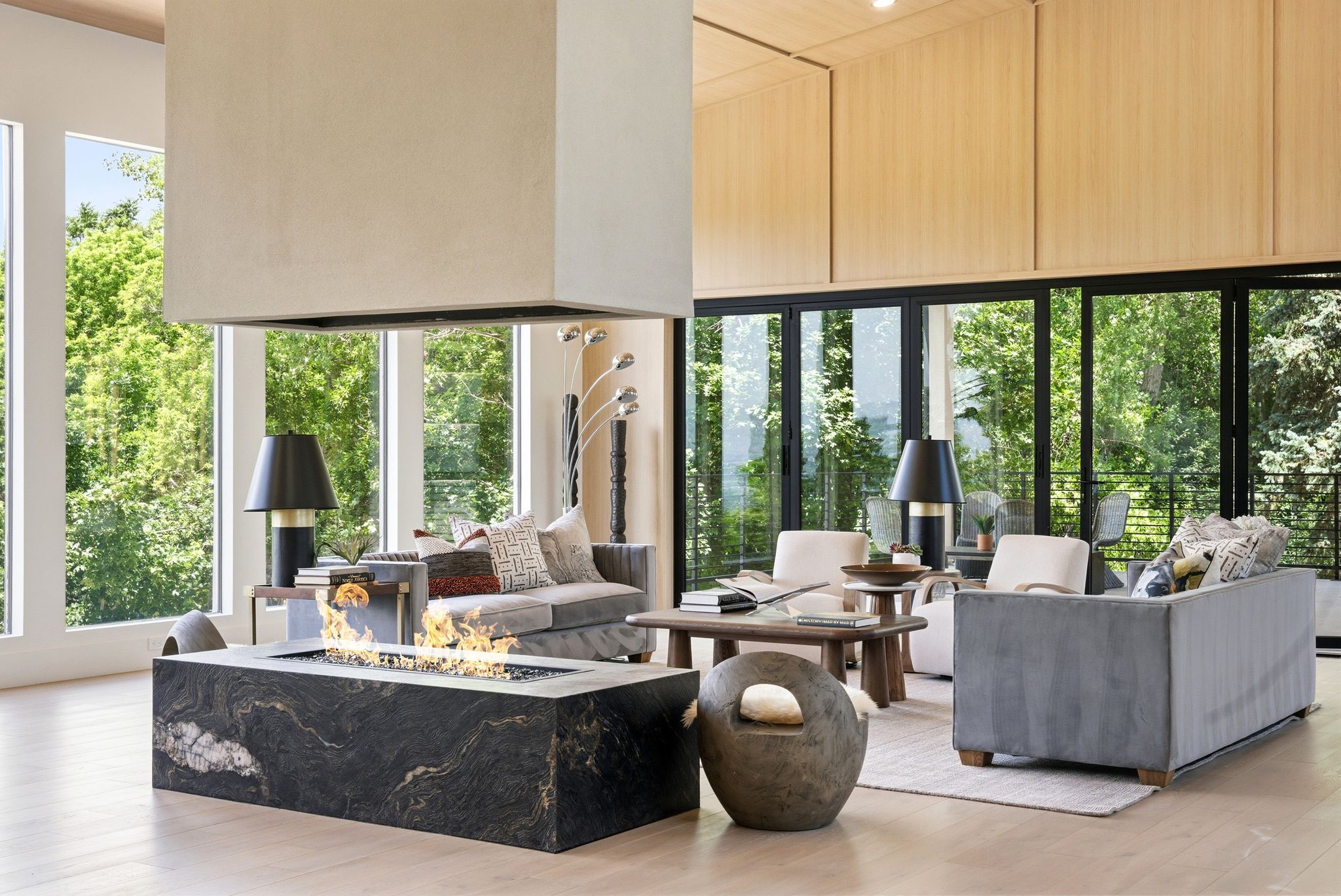 Open-concept living space with a suspended fireplace over a granite-clad firebox