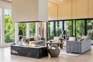 Open-concept living space with a suspended fireplace over a granite-clad firebox