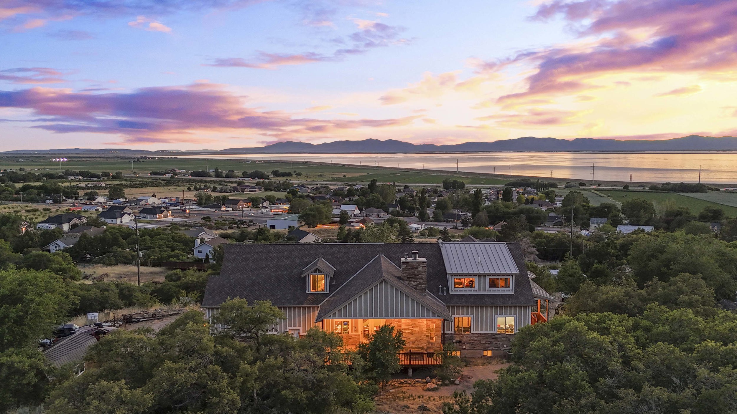 Two-story residence with horizontal siding, stone accents, and a shingle roof