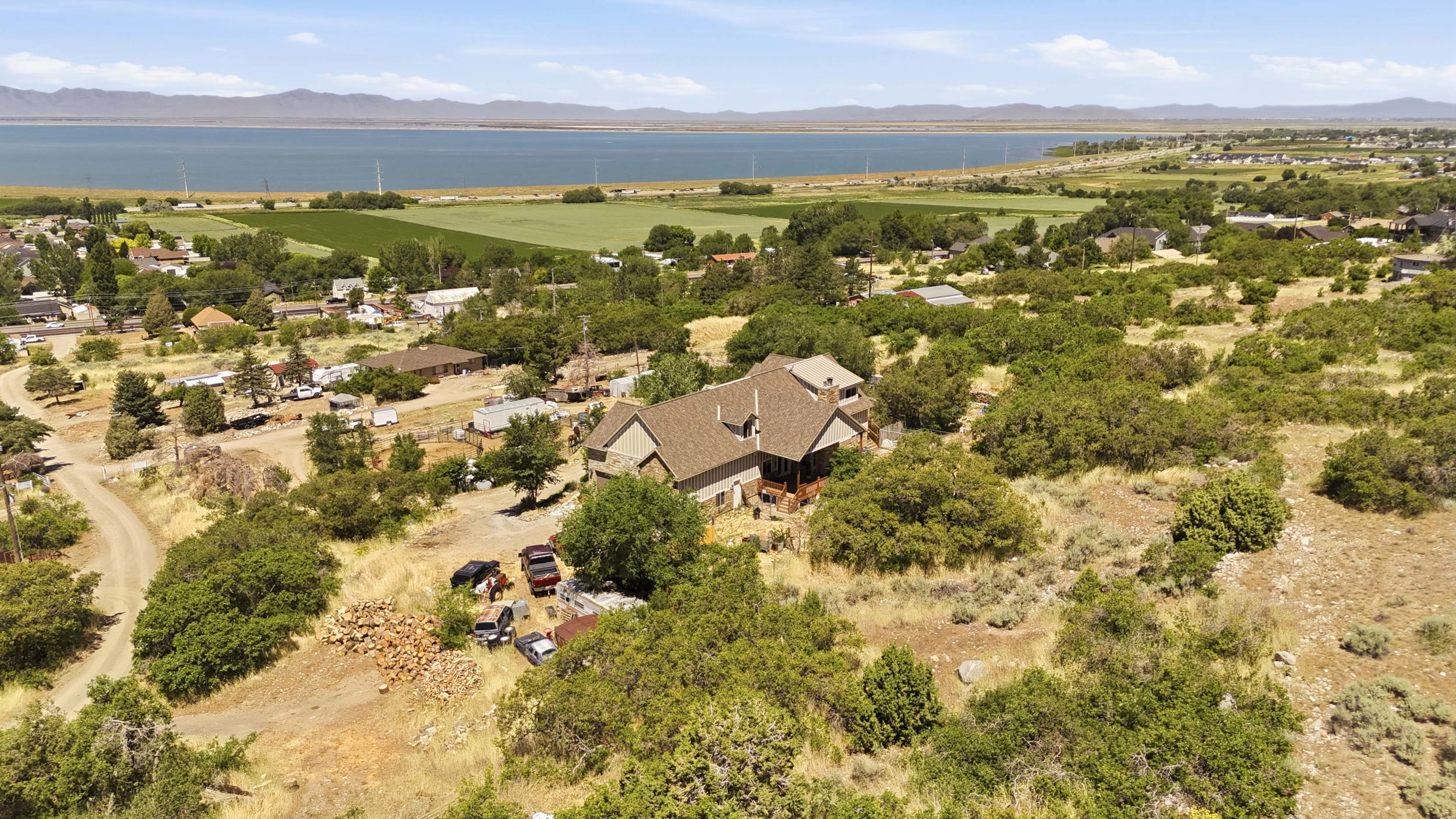 Property situated amidst natural landscaping, featuring a multi-level structure with a gabled roof