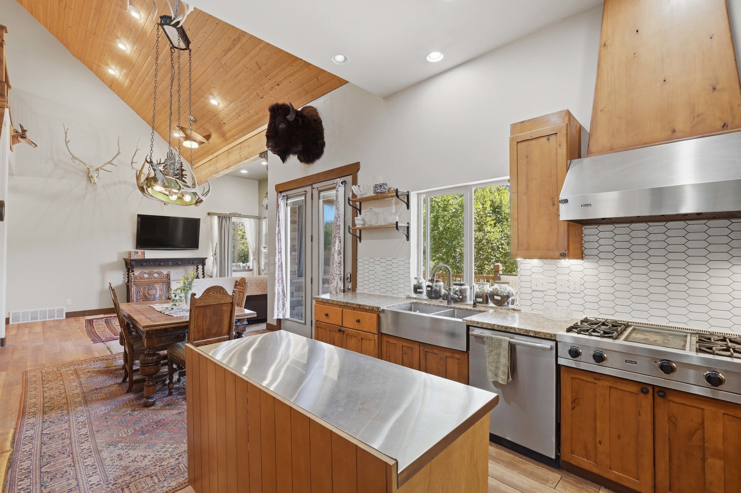Open-concept kitchen and dining area with vaulted wood-plank ceilings