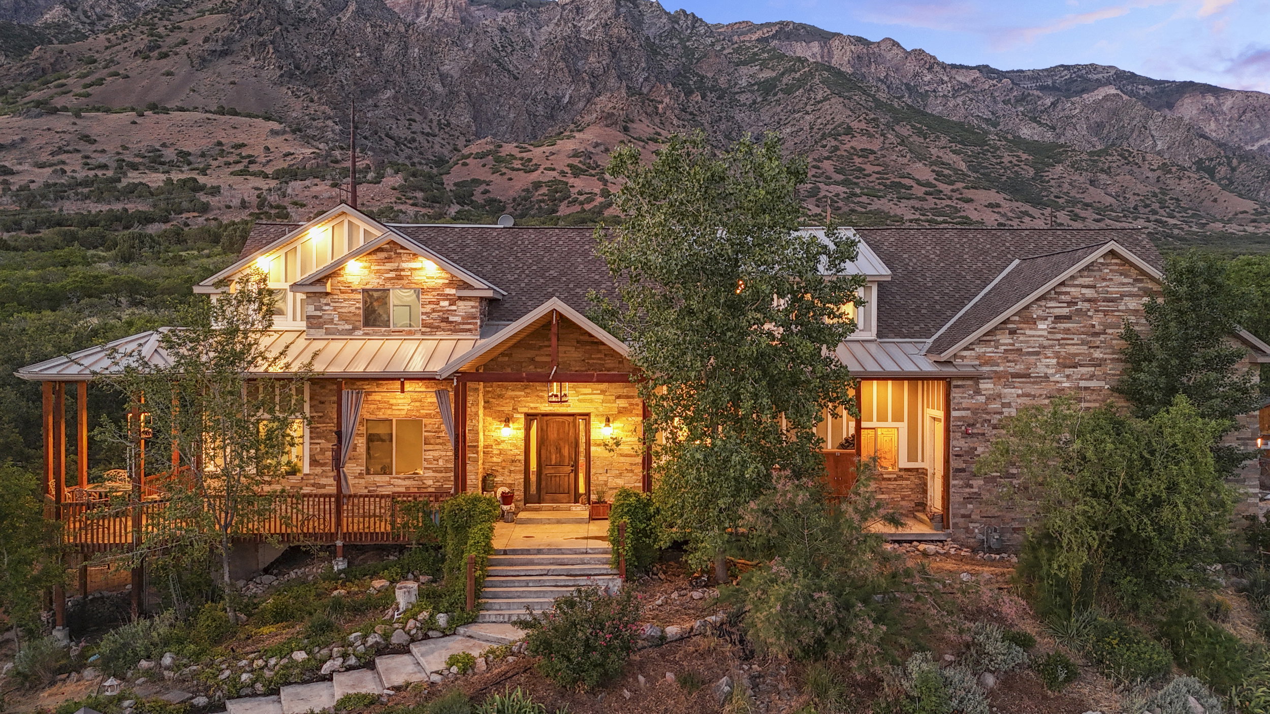 Stone veneer exterior with wood accents and a shingle roof