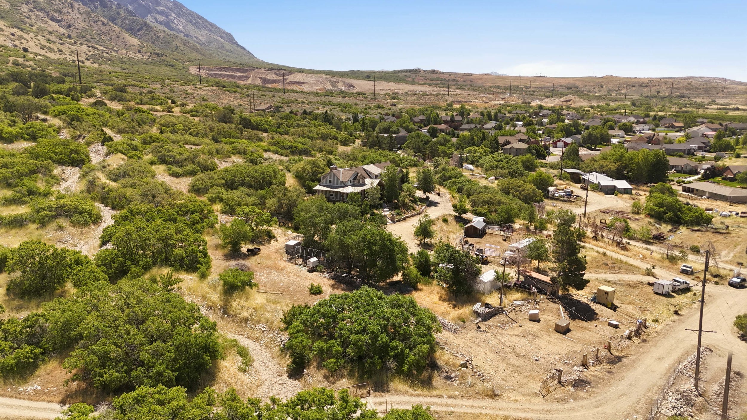 Expansive property featuring a two-story residence, mature trees, and a mountainous backdrop