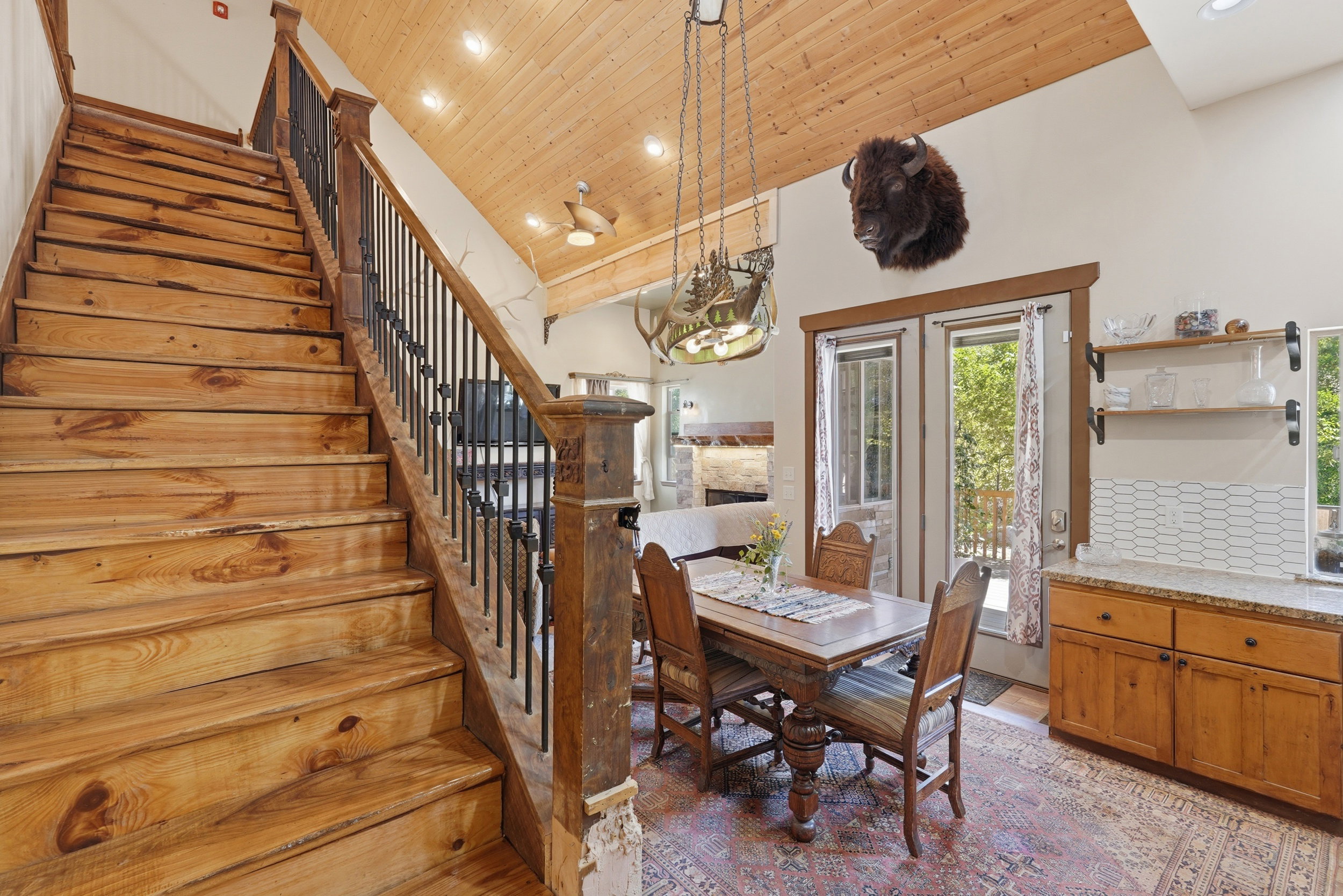 Natural wood staircase with wrought iron balusters and carved newel posts