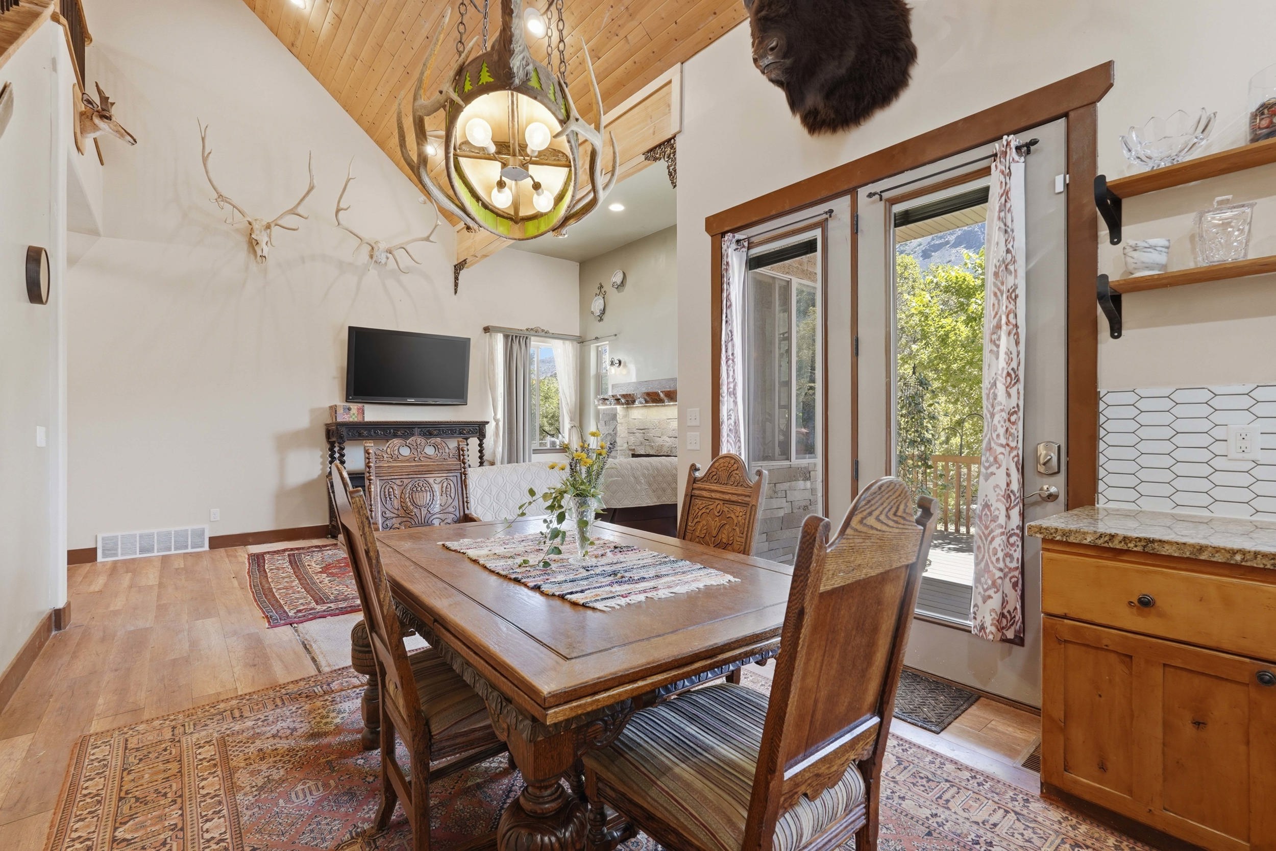 Vaulted wood-paneled ceiling, wood-finish flooring, and double glass-paneled exterior doors