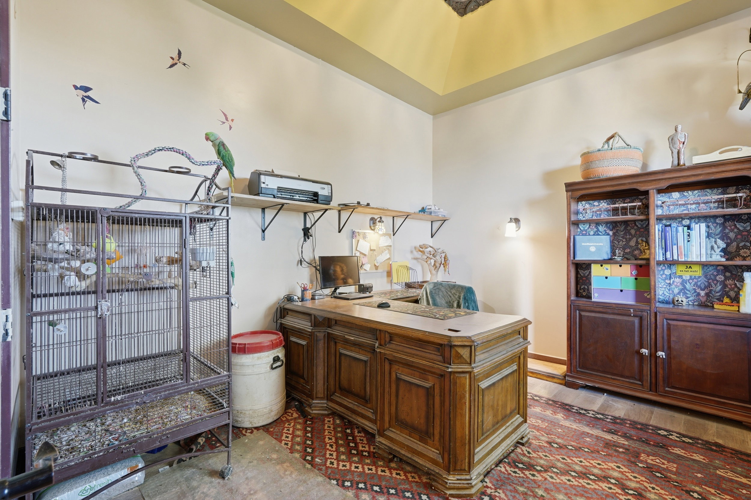Room featuring a wood-finish desk, a built-in bookshelf with lower cabinetry, and wall-mounted shelving
