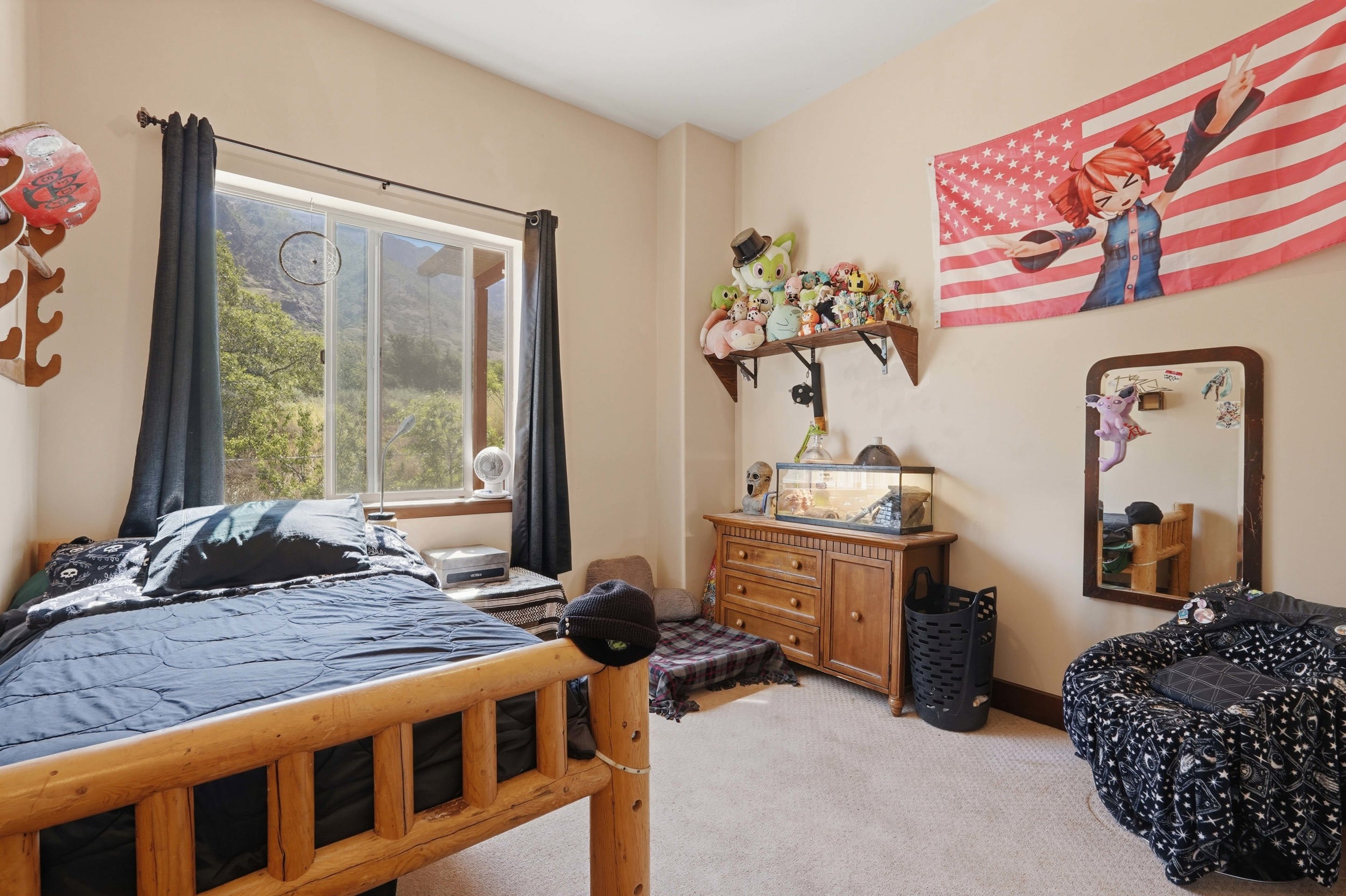 Inviting room featuring a large window with exterior scenery, neutral wall paint, and light-toned carpeting