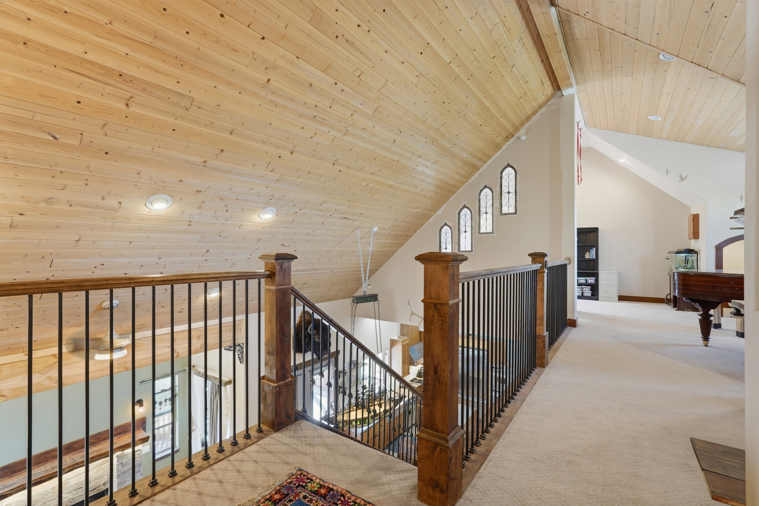 Loft space featuring a vaulted wood-paneled ceiling, recessed lighting, and light-colored carpeting