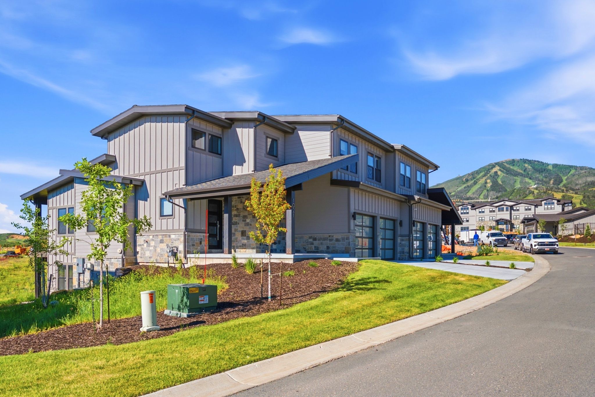 Contemporary multi-level residence featuring vertical siding and stone accents