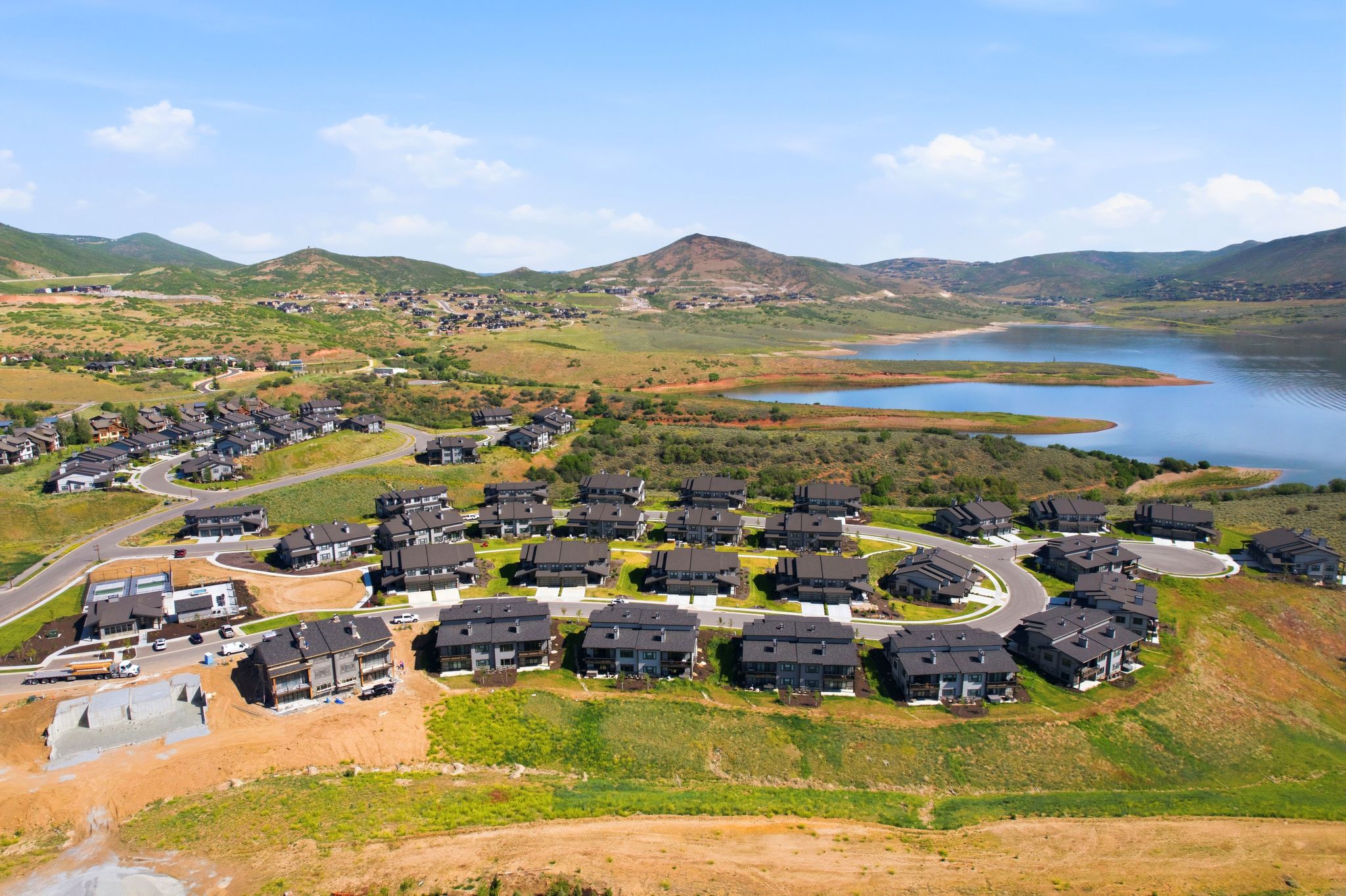 Aerial overview of a residential development featuring multiple dark-roofed homes