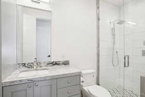 Bathroom featuring a gray vanity with an undermount sink and a light-toned, veined countertop