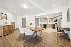 Open-concept kitchen and dining area featuring wood-finish flooring, recessed lighting, and a neutral color palette