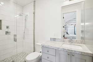 Bathroom featuring a glass-enclosed shower with white subway tile, a decorative mosaic tile shower floor, and a built-in shower niche