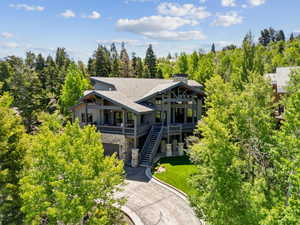 Mountain-style residence featuring a stone and wood exterior with multiple balconies