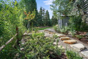 Stone paver pathway with gravel infill, leading through varied landscaping