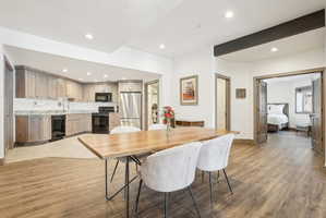 Open concept living space featuring wood-finish flooring, recessed lighting, and a dark wood beam accent