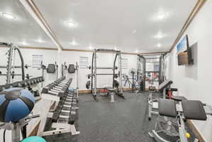 Dedicated fitness space featuring rubber flooring and mirrored wall