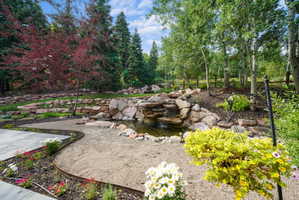 Tiered rock waterfall feature emptying into a pond