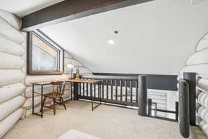 Loft area featuring white log walls, a dark wood-framed window, and exposed wood ceiling beams