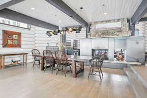 Expansive dining area featuring wood-finish flooring and exposed log walls