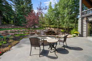 Spacious patio featuring stone-finish pavers and a built-in fire pit