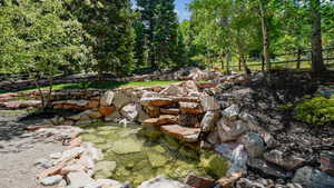 Tiered rock waterfall feature emptying into a clear pond
