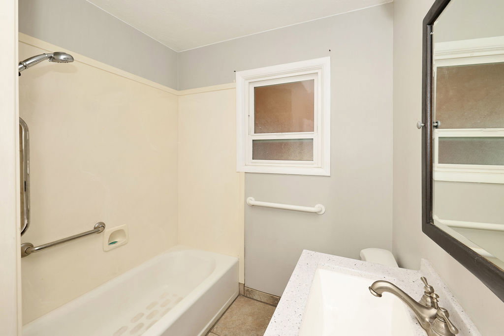 Bathroom vanity featuring a speckled countertop and brushed nickel faucet