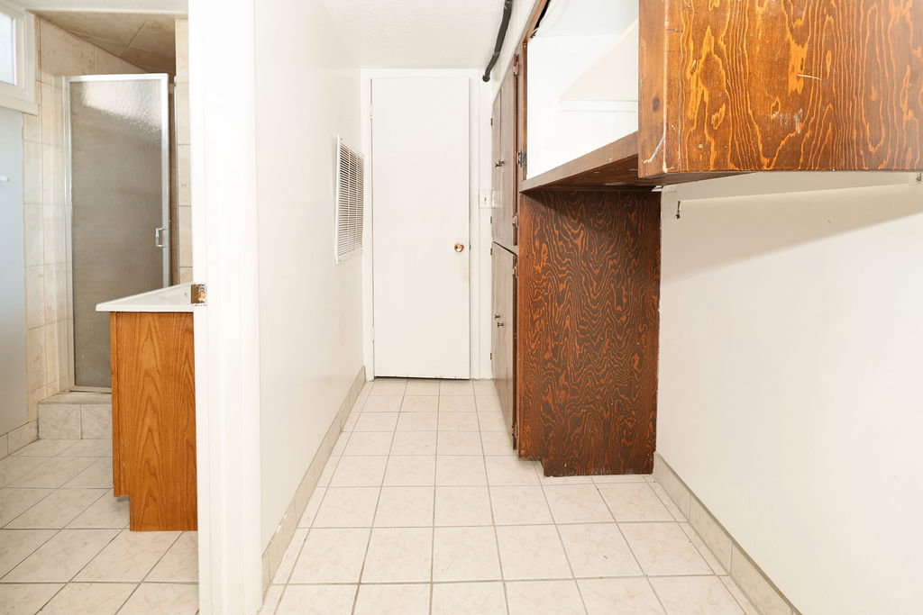 Hallway featuring tile flooring and built-in wood-finish cabinetry