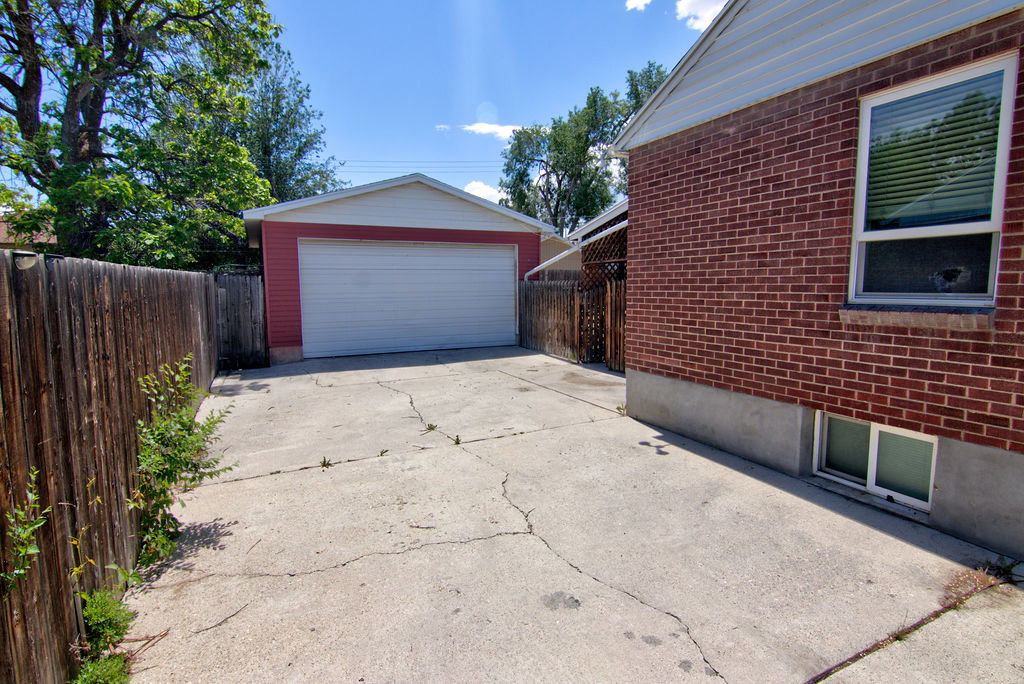 Detached two-car garage with a white overhead door and red siding