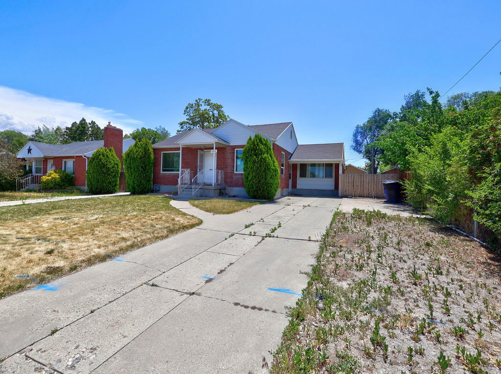 Brick exterior featuring a covered front porch and a paved driveway