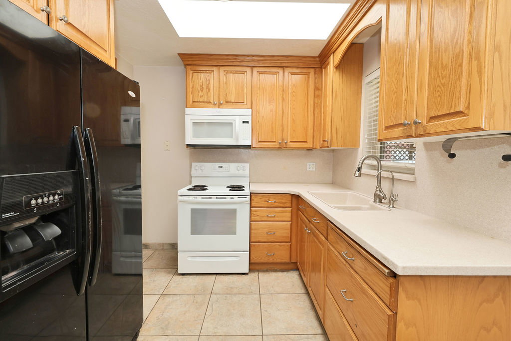Kitchen with light wood cabinetry, light countertops, and tile flooring