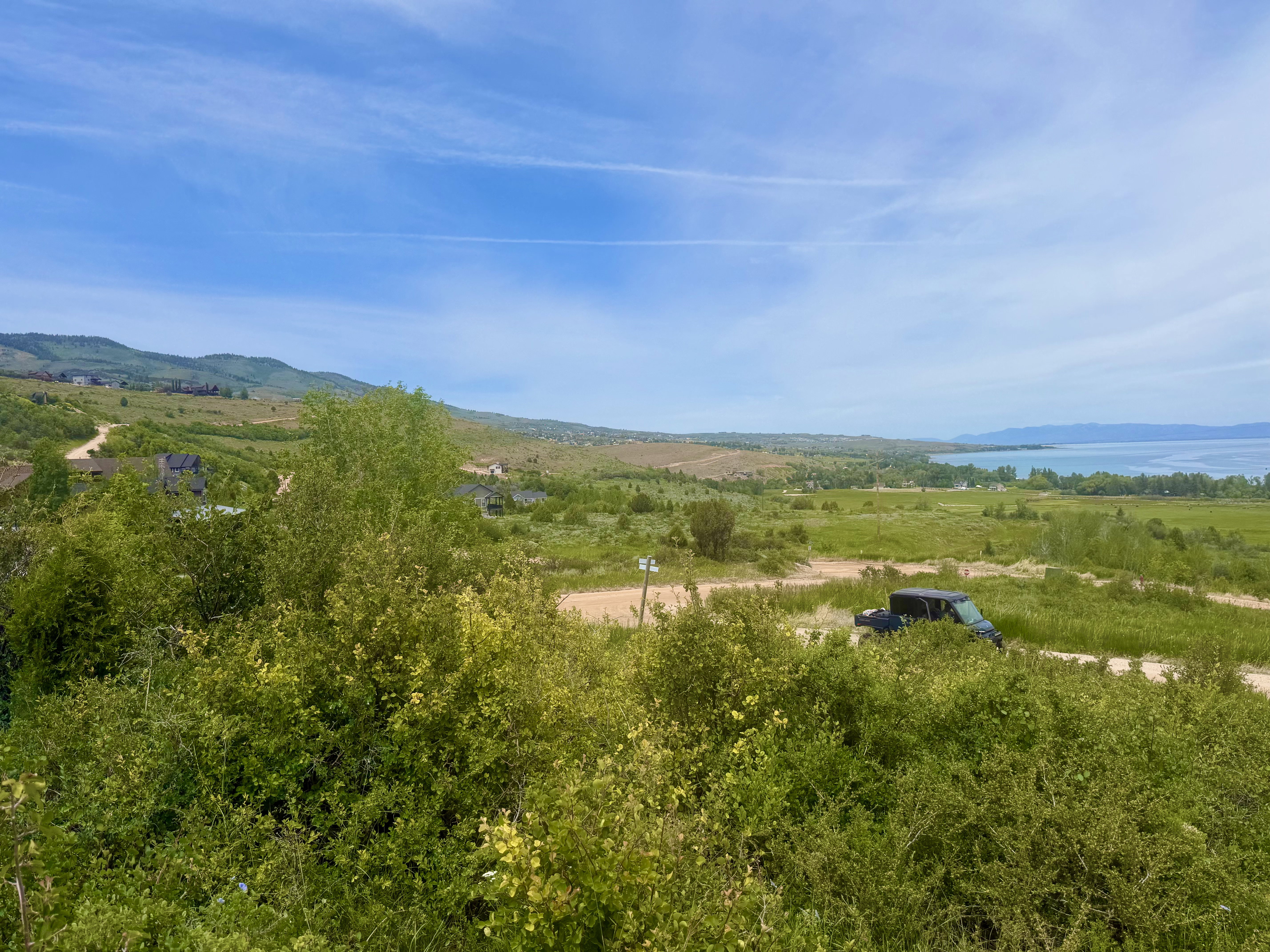Expansive terrain with distant water frontage and mountain backdrop